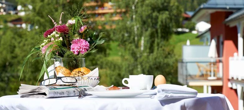 Frühstückstisch auf der Terrasse. Im Hintergrund sind die Berge